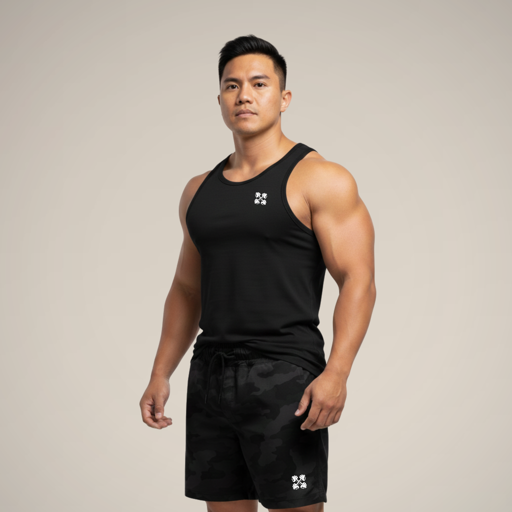 Man wearing a black tank top and shorts with a logo on a beige background